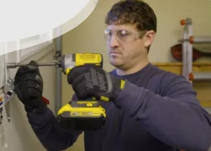 Space City Garage Doors technician repairing a garage door with a power drill